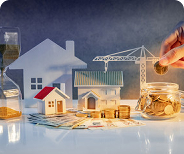 Wealth Management - miniature houses and coins being placed into a jar